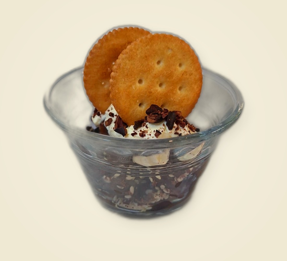 Postre de cerezas de café de Cielo Adentro, con crema, cacao y galleta